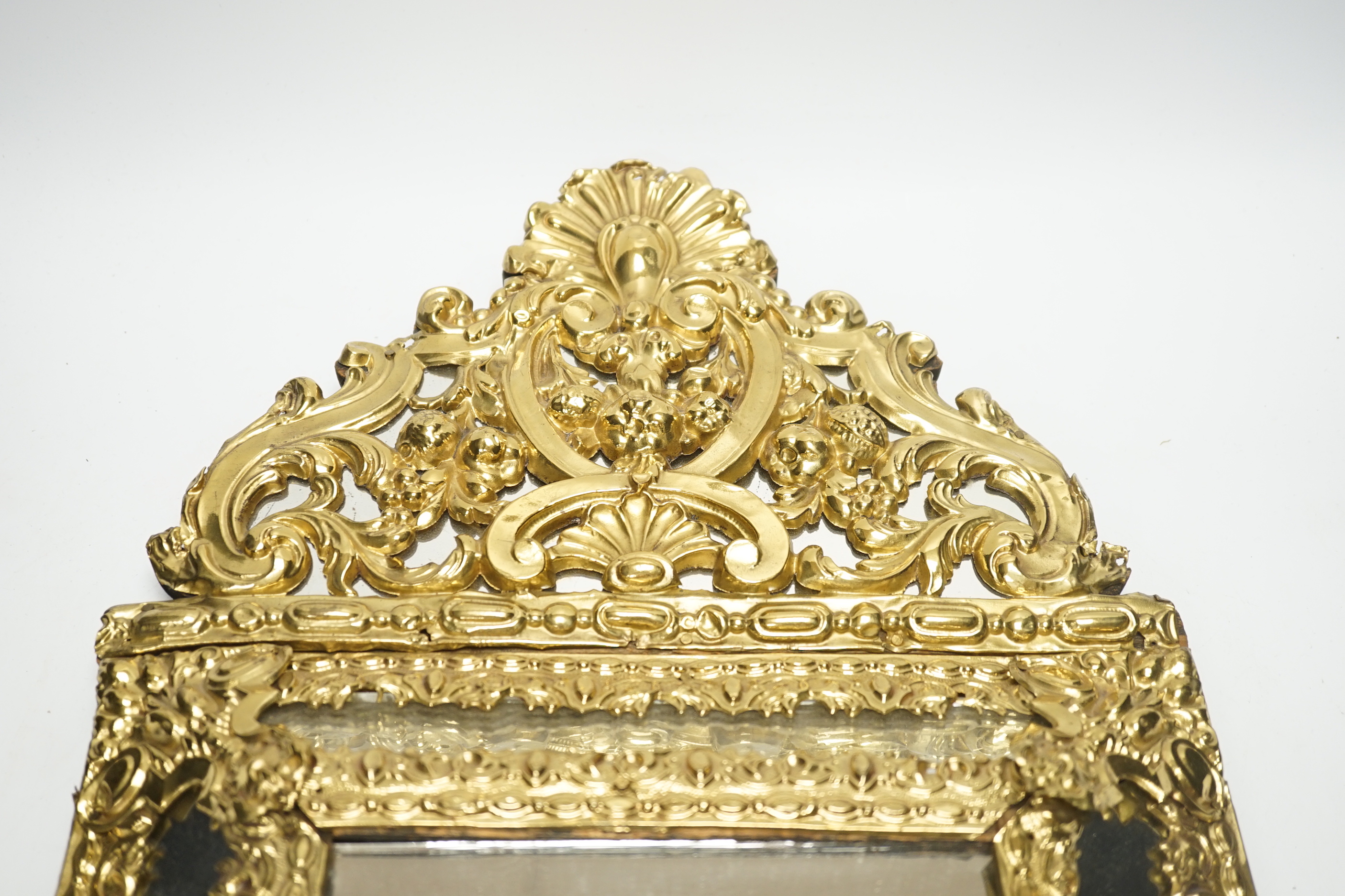 An 18th century-style embossed brass mirror, 58cm high